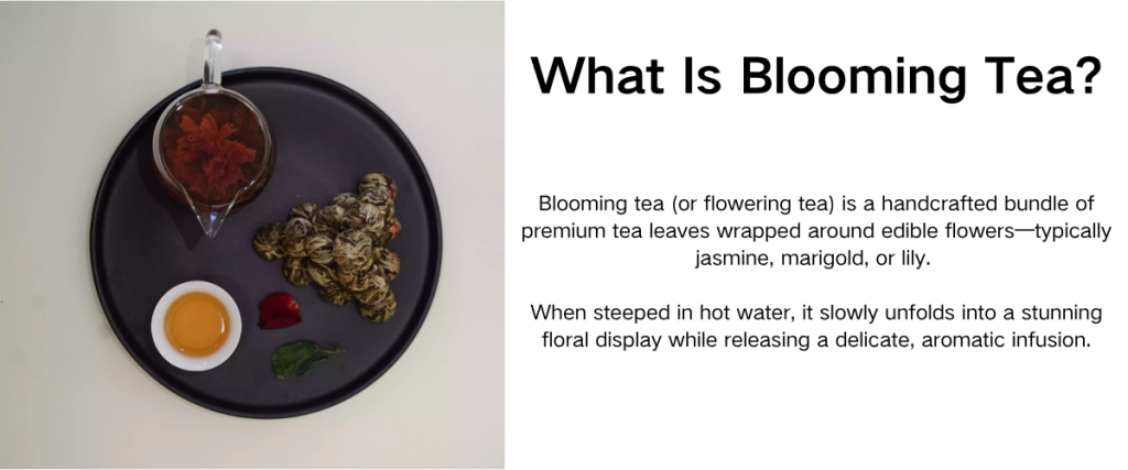A glass server of red blooming tea beside tied blossoms on a dark tray